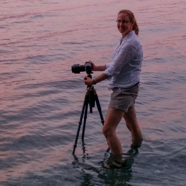 Kristin taking photos in a glacial lake in NZ